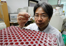 Yasuhiro Kato, an associate professor at the University of Tokyo, looks at a Pacific Ocean mud sample (Reuters/Yuriko Nakao)