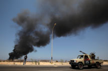  Libyan rebel vehicle passing burning oil tank (Reuters/Darrin Zammit Lupi)