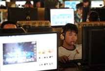 A man smokes as he uses a computer at an internet cafe in Hefei,  Anhui province, September 15, 2011(Reuters)