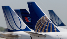 A Continental Airlines plane is parked next to United Airlines  planes.(Reuters/John Gress)