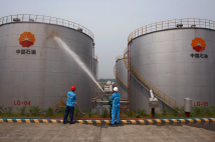  Employees spray water to cool down oil tanks at a PetroChina oil storage facility in Suijing, China.(REUTERS/Stringer)