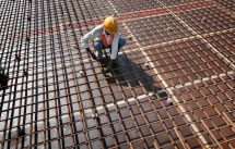 A worker fastens iron rods together at the construction site of a  bridge on Srinagar-Jammu national highway in India.(REUTERS/Mukesh Gupta) 