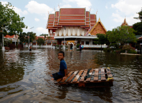 A boy plays in a flooded temple compound at Bang Phlat district in Bangkok.(REUTERS/Chaiwat Subprasom)