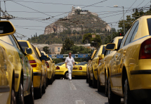 A taxi driver walks between stationary taxis during a protest in  central Athens.(REUTERS/John Kolesidis)