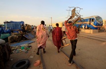 People carry luggage to a train to South Sudan. (REUTERS/Mohamed Nureldin Abdallah)