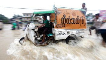 A vehicle moves on a flooded street in Burma. (REUTERS/Soe Zeya Tun)