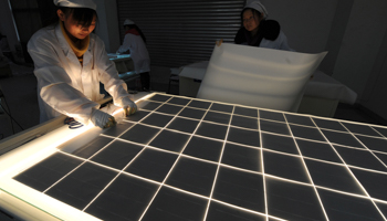 Employees work on solar panel production line. (REUTERS/Jianan Yu)