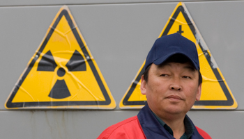 A worker stands in front of radioactivity signs at Khorasan-1 uranium mine in Kazakhstan. (REUTERS/Shamil Zhumatov)