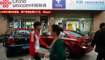 People walk past China Unicom and China Telecom stores in Shanghai. (REUTERS/Aly Song)