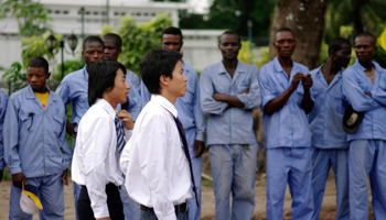 Chinese contractors walk past Congolese workers in Kinshasa. (REUTERS/Katrina Manson)
