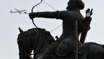 A Kingfisher Airlines aircraft flies pasts a statue of Chauhan in New Delhi. (REUTERS/B Mathur)