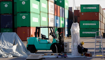 A worker sits at a container area at a port in Tokyo. (REUTERS/Toru Hanai)