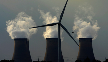 A wind turbine near a coal-fired power plant. (REUTERS/Nigel Roddis)