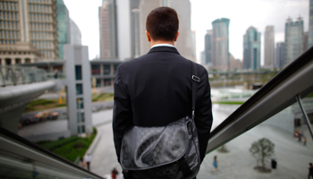 A business man rides an escalator in the financial district of Pudong, Shanghai. (REUTERS/Aly Song)