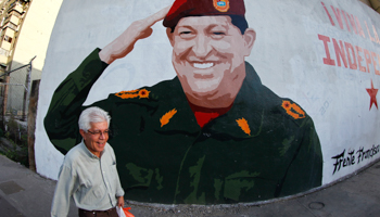 A man walks past a mural depicting President Hugo Chavez in Caracas. (REUTERS/Jorge Silva)