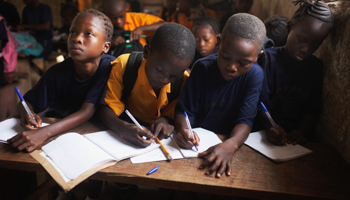 Students share a desk at a school in Sierra Leone. (REUTERS/Finbarr O'Reilly)