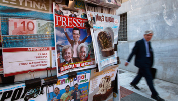 A man walks past newspaper kiosk in Athens. (REUTERS/Pascal Rossignol)