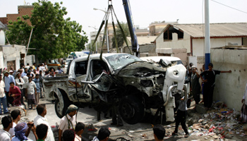 The car of a military commander is lifted following a suicide bomb attack in Aden. (REUTERS/Stringer)