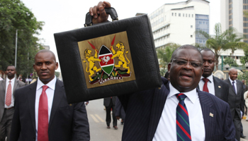 Kenya's Finance Minister Robinson Githae displays the briefcase containing his speech as he walks to present the budget. (REUTERS/Noor Khamis)