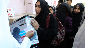 A Syrian refugee receives humanitarian aid from a charity organisation in Amman. (REUTERS/Ali Jarekji)