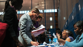 Job seekers speak to recruiters at a job fair in New York (REUTERS/Keith Bedford)