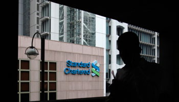 A man passes the Standard Chartered headquarters in Hong Kong (REUTERS/Bobby Yip)