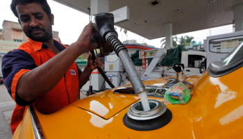 An employee fills a taxi at a fuel station in Kolkata (REUTERS/Rupak De Chowdhuri)