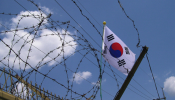 A South Korean flag seen through barbed wire at the border (istockphoto/gkgraphics)