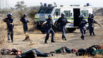 South African policemen with some of the dead miners (REUTERS/SIPHIWE SIBEKO)