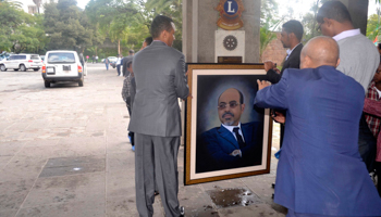 Officials move a portrait of Meles Zenawi (REUTERS/Stringer)