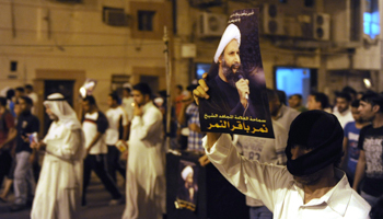 A protester holds up a picture of Sheikh Nimr during a rally in Qatif (REUTERS/Stringer)