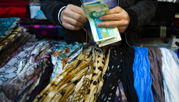 A shopkeeper in Tehran counts Iranian banknotes (REUTERS/Raheb Homavandi)