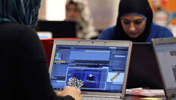 Young entrepreneurs work on their laptops at a seed investment firm (REUTERS/Muhammad Hamed)