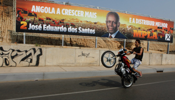A motorcyclist rides past an election poster of President Jose Eduardo dos Santos (REUTERS/SIPHIWE SIBEKO)