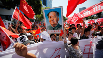 Protesters hold posters of Chairman Mao Zedong and  national flags during a protest in Shanghai (REUTERS/Aly Song)