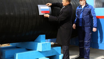 Gazprom CEO Alexei Miller attaches a Russian flag to the Nord Stream pipeline (REUTERS/Alexander Demianchuk)