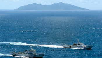 A Chinese marine surveillance ship cruises as a Japan Coast Guard ship sails near the disputed islands (REUTERS/KYODO Kyodo)