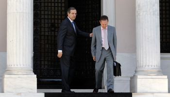 Prime Minister Samaras escorts Finance Minister Stournaras after a meeting with coalition party leaders (REUTERS/Yorgos Karahalis)