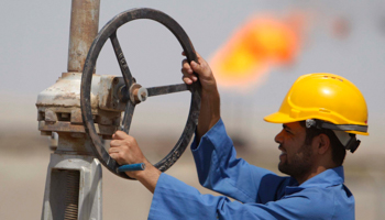 A worker adjusts a pipe at the Nassiriya oilfield in Iraq (REUTERS/Atef Hassan)