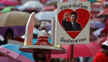 A Thai 'red shirt' supporter holds up a picture of former Prime Minister Thaksin Shinawatra (REUTERS/Sukree Sukplang)