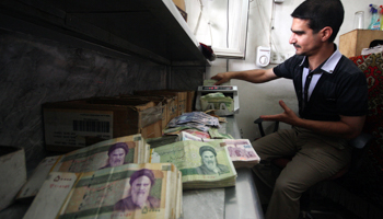 A man counts Iranian rials at a currency exchange shop in Iraq (REUTERS/Mushtaq Muhammad)