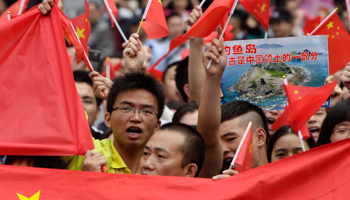 Protesters hold a poster showing the Senkaku/Diaoyu islands on the anniversary of Japan's invasion of China (REUTERS/Stringer)