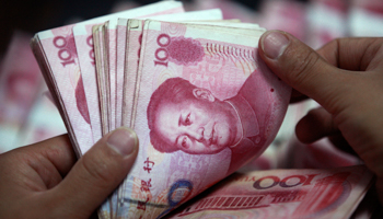 A bank clerk counts renminbi banknotes (REUTERS/Stringer China)