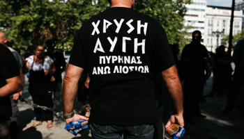 A Golden Dawn supporter distributes packs of pasta to residents in Athens (REUTERS/Yorgos Karahalis)