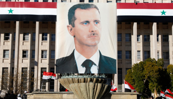 A portrait of President Bashar al-Assad hangs in front of the central bank in Damascus (REUTERS/Khaled Al Hariri)