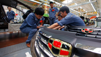 Employees check vehicles along an automobile assembly line in China (REUTERS/Carlos Barria)