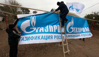 Employees install banners displaying Gazprom insignia (REUTERS/Eduard Korniyenko)
