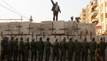 An anti-Morsi protester demonstrates in front of soldiers guarding the presidential palace (REUTERS/Asmaa Waguih)