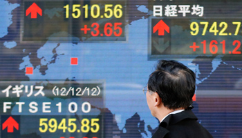A man looks at an electronic board outside a brokerage in Tokyo (REUTERS/Yuriko Nakao)