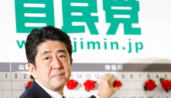 Shinzo Abe puts paper roses on names of LDP candidates expected to win (REUTERS/Yuriko Nakao)